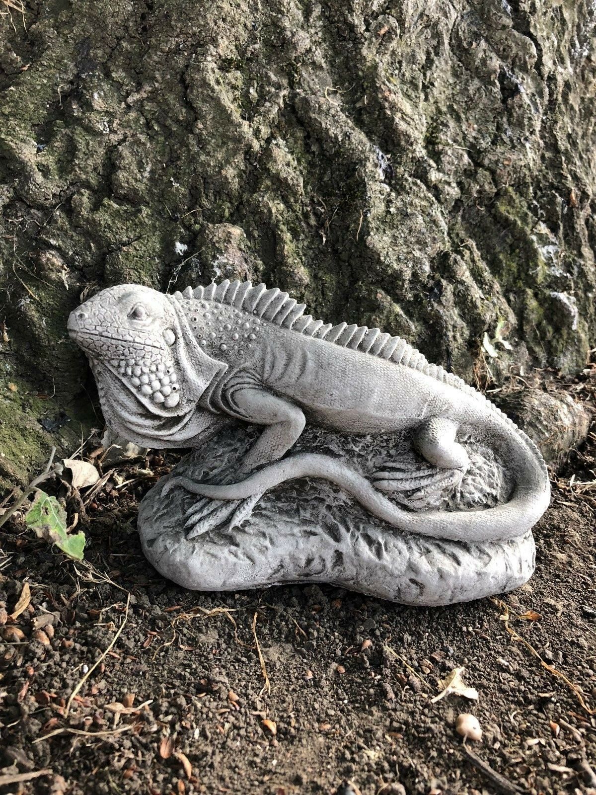 Realistic iguana garden sculpture from the Stone Collection placed at tree base, made from frost-resistant limestone for year-round display.