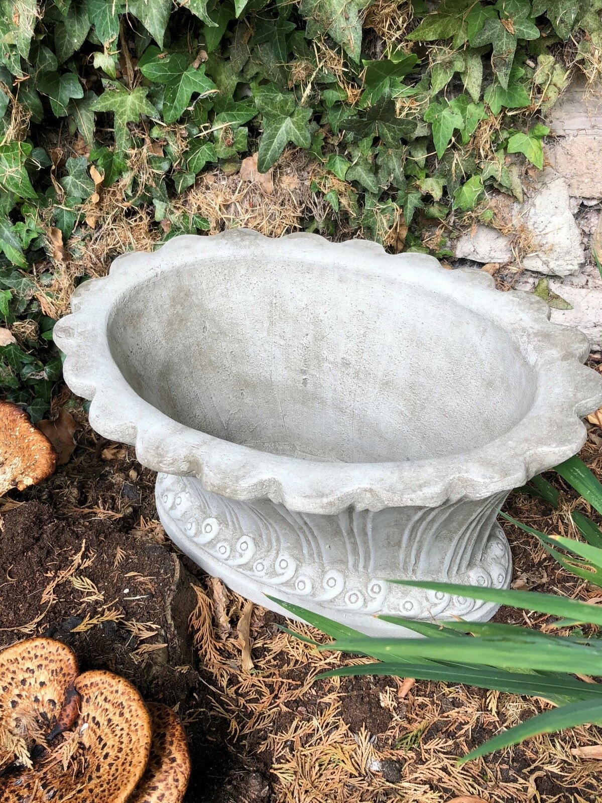 Top view of fluted stone garden pot planter with scalloped rim, ideal for planting flowers or ornamental greenery outdoors.