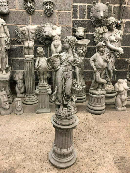 Stone Roman Lady Garden Statue in limestone on fluted plinth, surrounded by classical sculptures, ideal for outdoor antique-style decor.