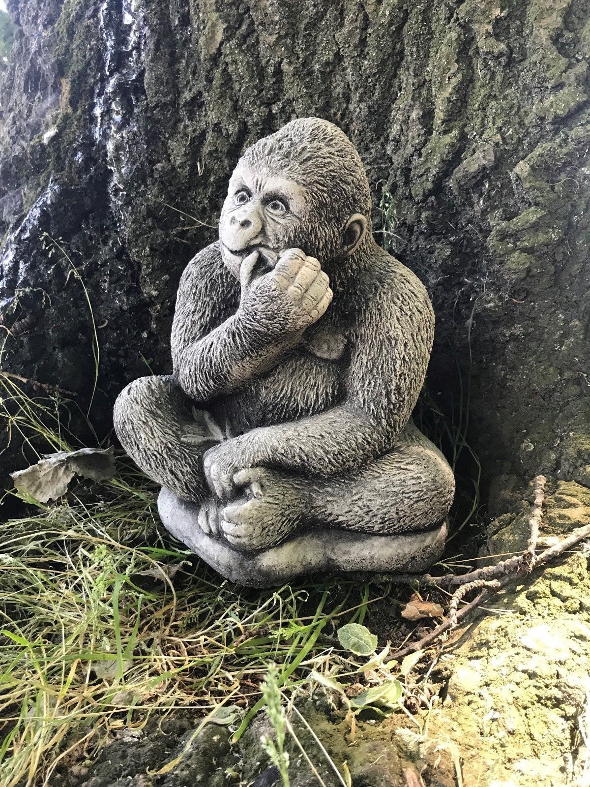 Side view of small stone gorilla ornament with realistic texture, placed outdoors for enhancing garden or patio decor.