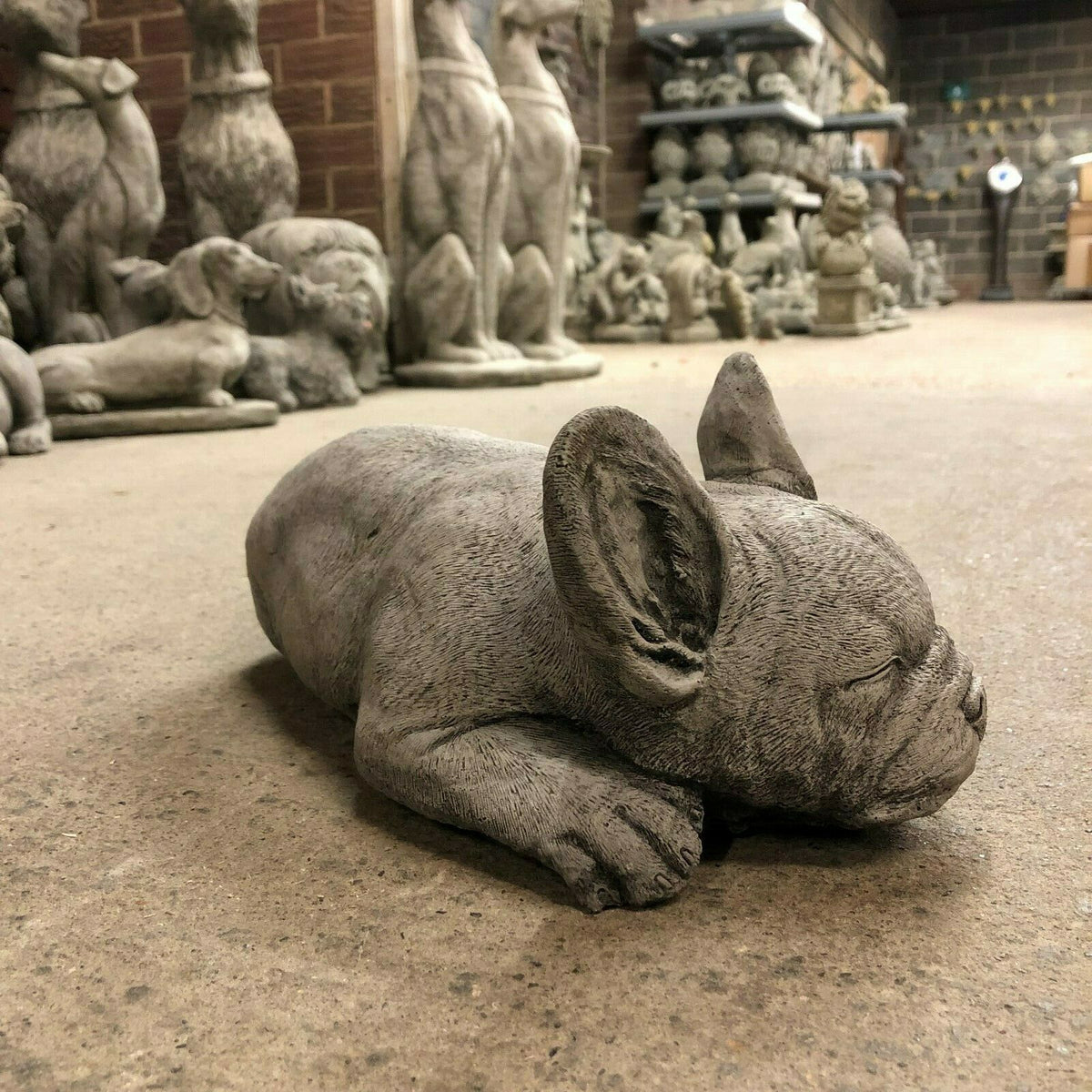 Angled side view of Stone Sleeping French Bulldog Garden Ornament, showcasing lifelike ears and serene expression for outdoor decor.