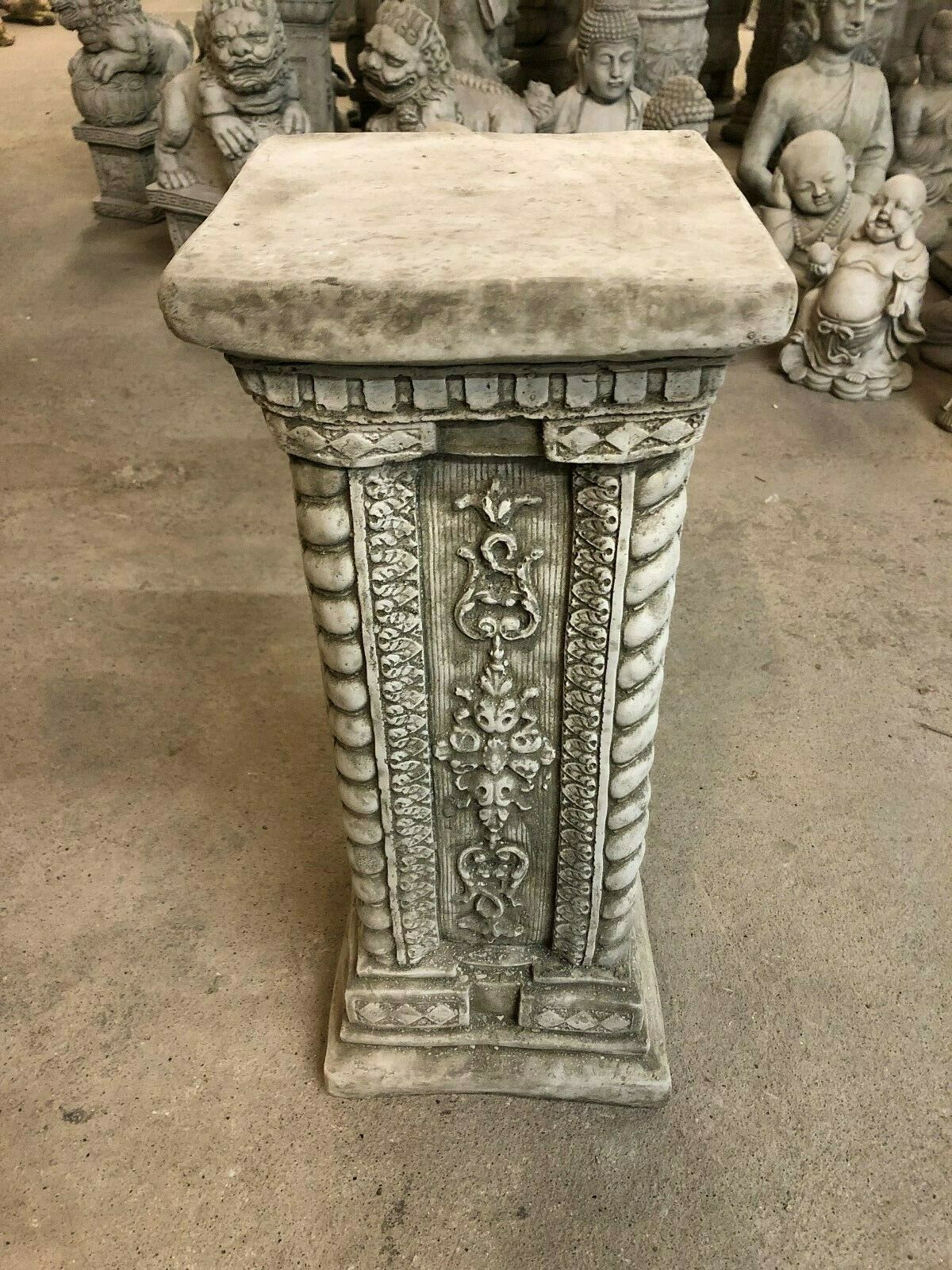 Tall square garden plinth in solid stone with intricate carvings and rope-style edges, perfect for showcasing statues or decorative figures outdoors.