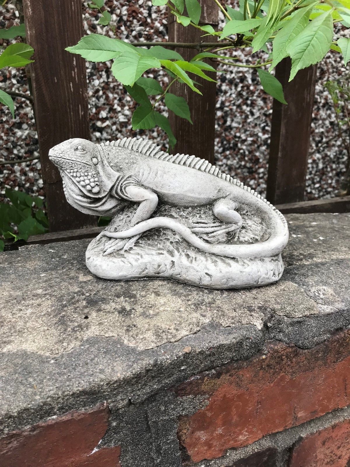 Lifelike stone iguana ornament from the Garden Collection on a brick ledge, crafted for outdoor durability and exotic garden styling.