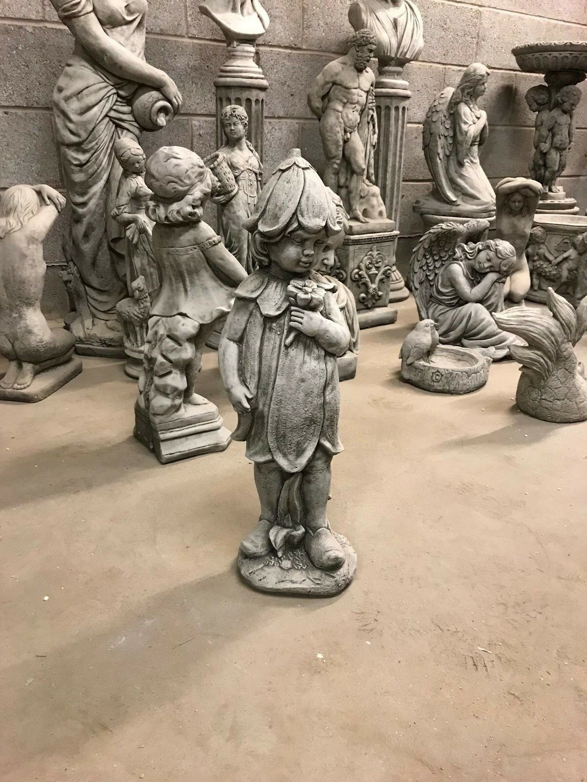 Full view of the Bluebell Girl Statue among other sculptures, emphasizing its size and suitability for decorative garden displays.
