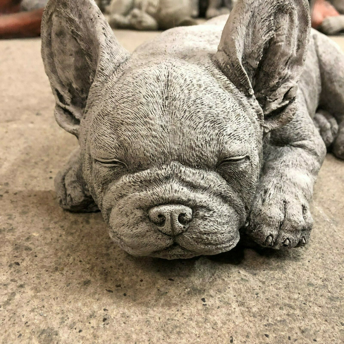 Close-up of French Bulldog Garden Ornament's face, emphasizing fine craftsmanship and peaceful sleeping pose in stone finish.