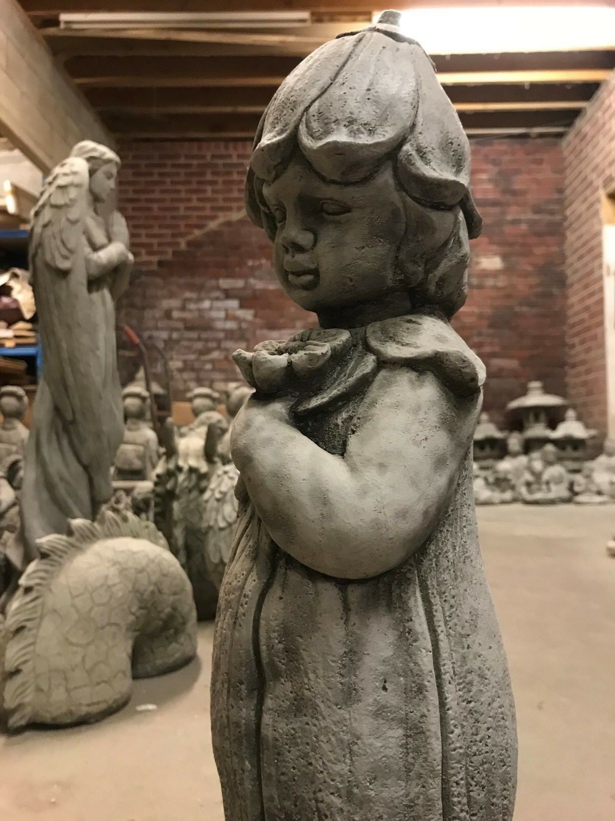 Side angle of the Bluebell Girl Statue showing serene expression and flower detail, perfect for enhancing garden aesthetics.