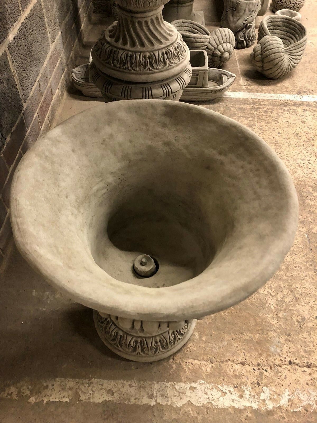 Top-down view of a Bacchus urn planter bowl with drainage hole, designed for outdoor planting and water management.