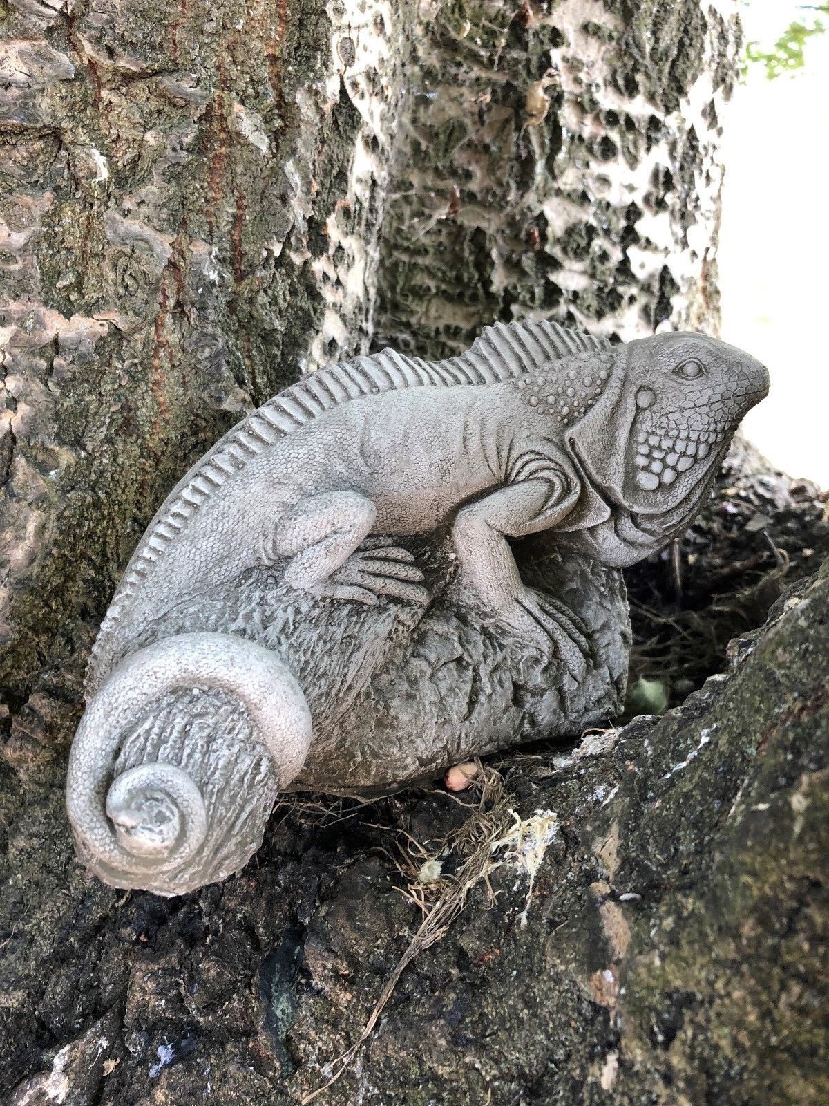 Limestone iguana sculpture nestled in tree roots, part of the Iguana Garden Ornaments - Stone Collection for outdoor garden decor.