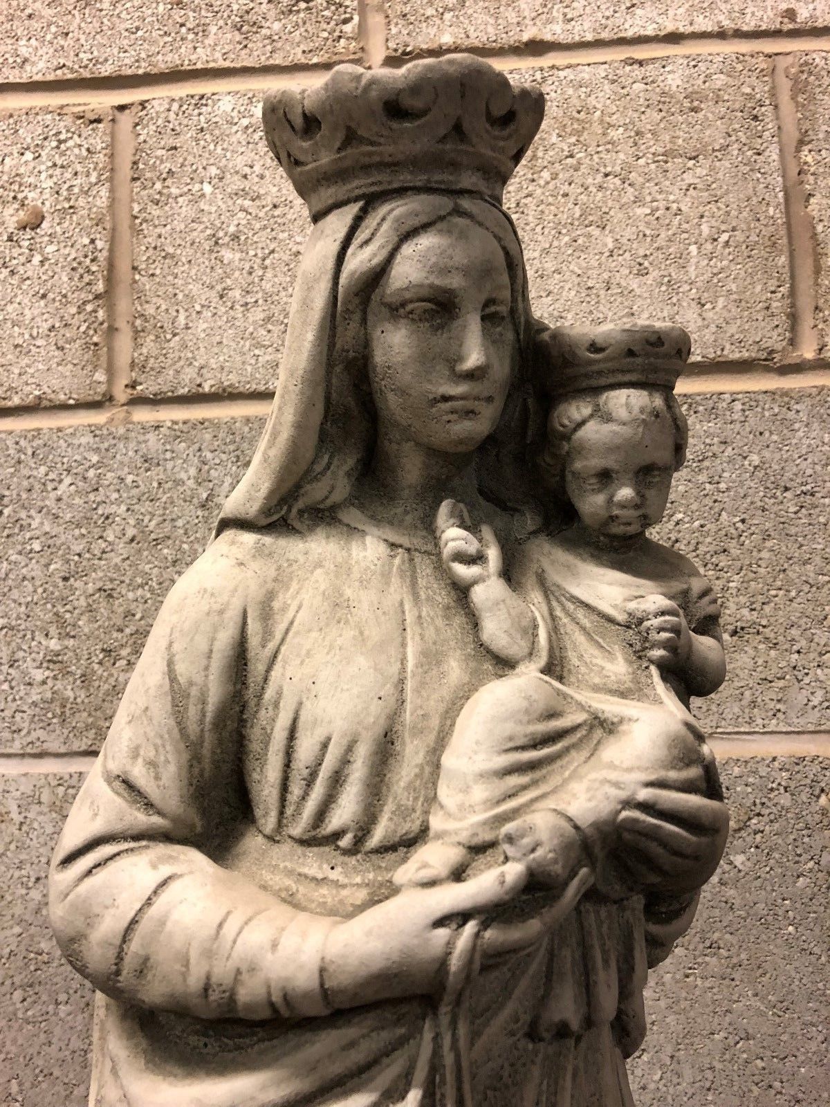 Detailed close-up of crowned Mary holding baby Jesus in grey stone, ideal for Christian garden sculpture or decorative patio feature.