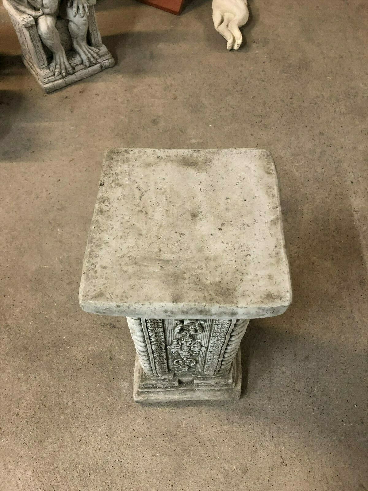 Top view of square stone garden column, showing flat surface suitable for supporting ornaments or planters in outdoor settings.