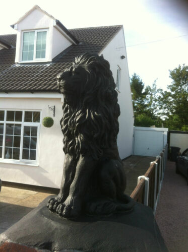 Close-up of black stone lion statue on gatepost, ideal for enhancing curb appeal with a classic guardian look.