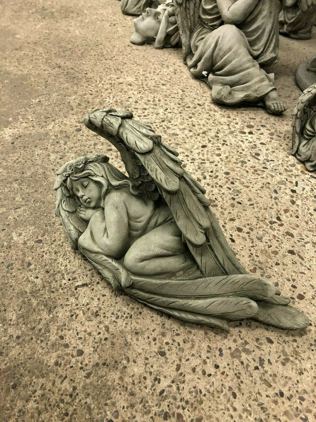 Durable Stone Angel Tiara Ornament curled in winged pose, ideal for garden decoration. Weather-resistant with intricate antique-style detailing.