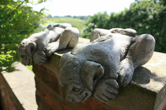 Pair of Gargoyle Garden Ornaments in stone design resting on a brick wall, ideal for outdoor decor with antique finish and durable limestone build.