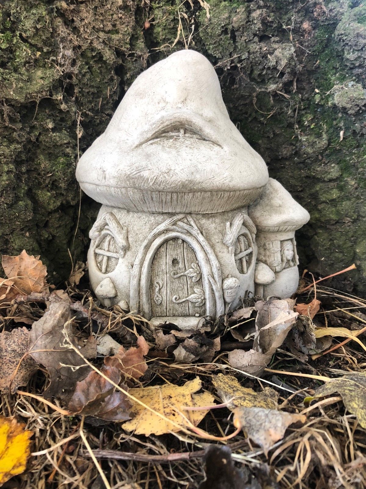Fairy Toadstool Garden Ornament - Stone House nestled among autumn leaves, ideal for whimsical outdoor garden decor.