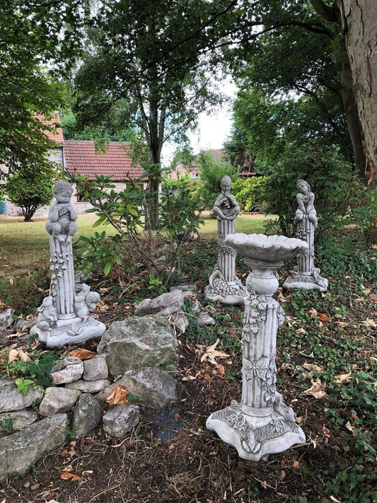 Stunning Stone Garden Statues - Four Seasons Statues displayed in a lush garden setting with detailed seasonal figures on ornate pedestals.