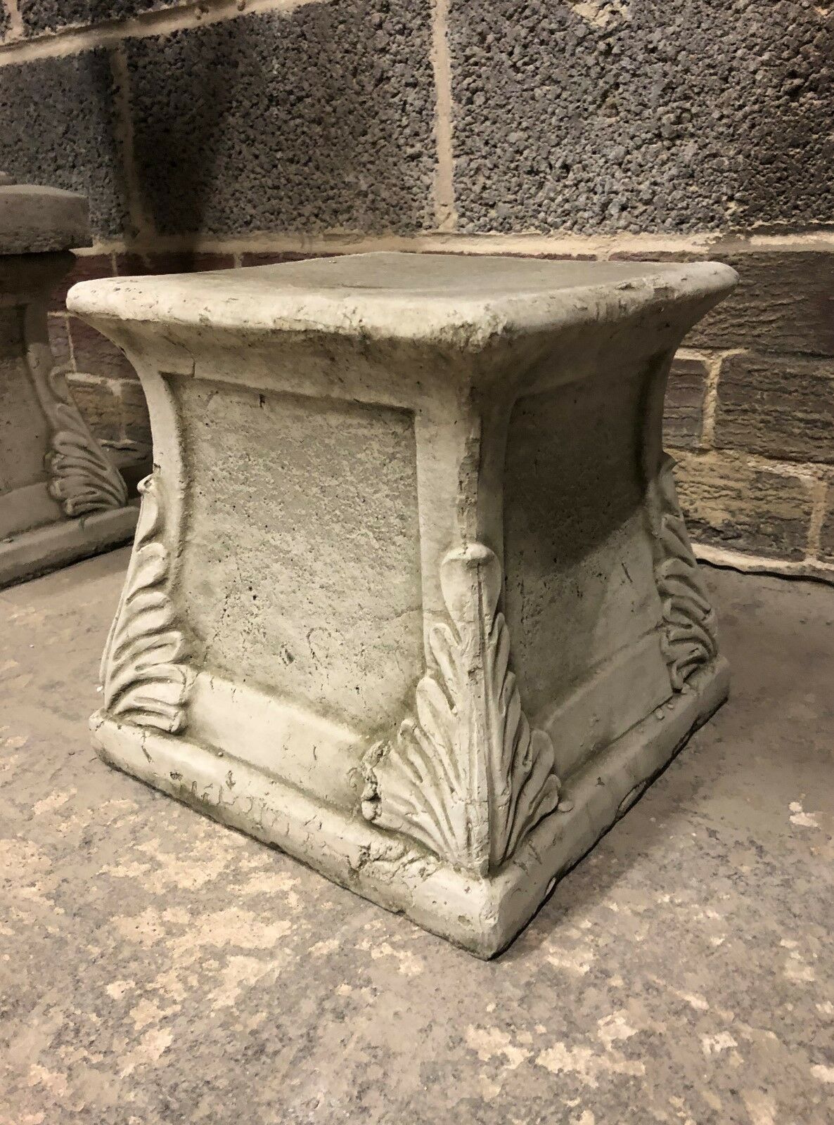 Handmade stone plinth with detailed leaf carvings, durable and weather-resistant, suitable for patios, gardens, or decorative displays.