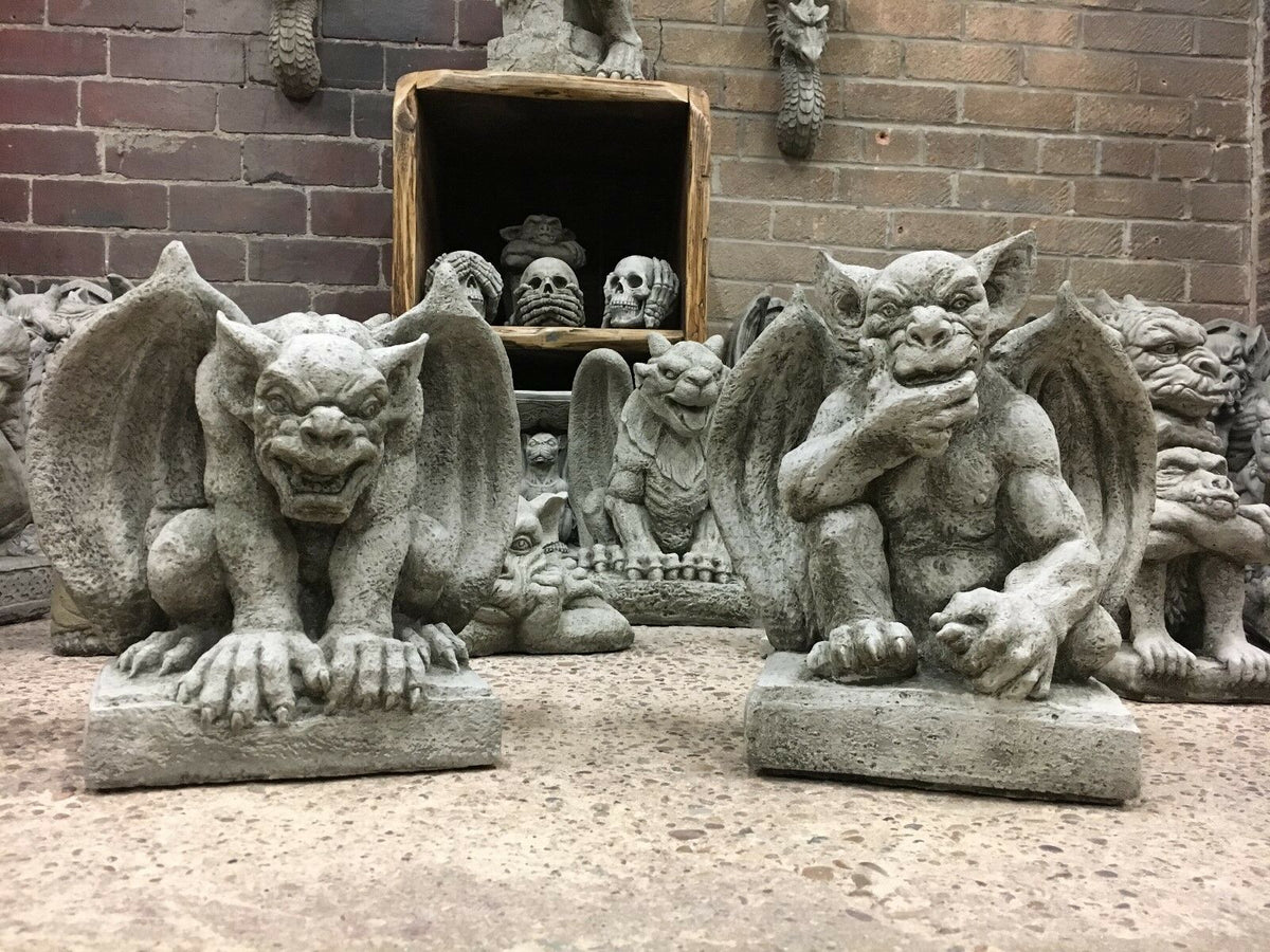 Winged stone gargoyle statues with fierce expressions, perfect for guarding garden entrances or patio spaces.