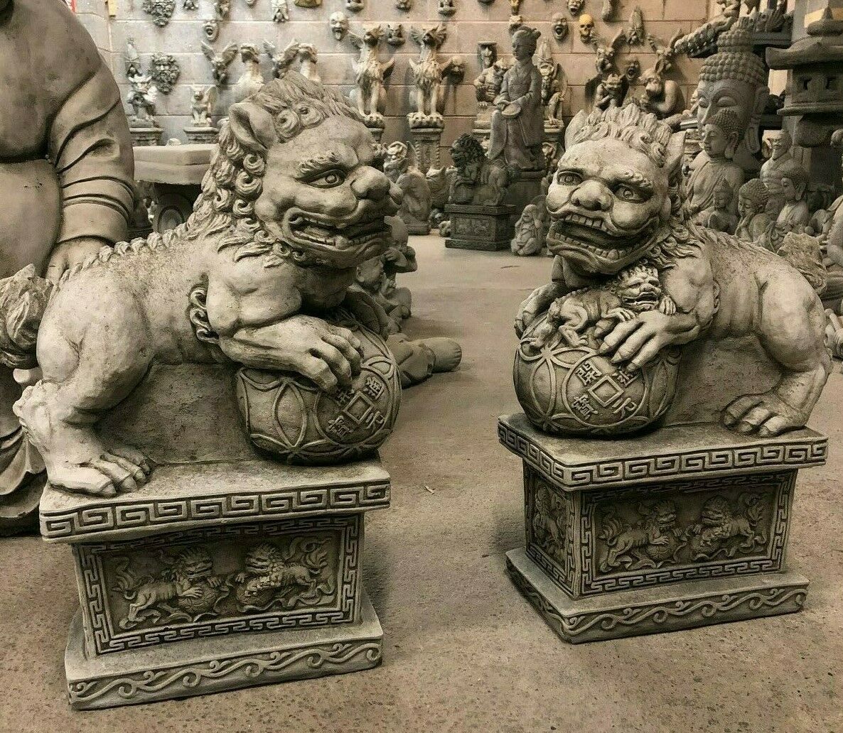 Pair of Chinese Stone Foo Dog Statues on ornate bases, crafted from weatherproof limestone for garden decor and symbolic protection.