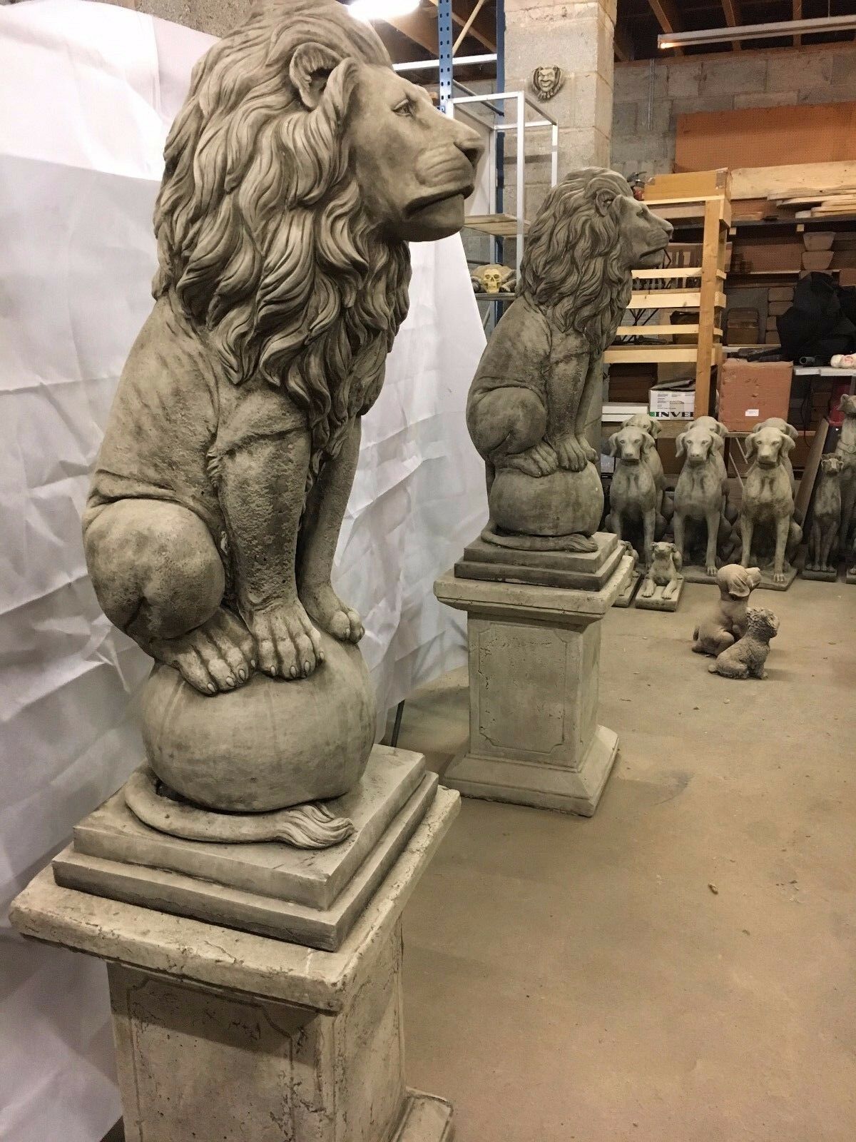 Stone lion statues on square plinths, crafted from limestone for durability, perfect for enhancing patios or garden landscapes.