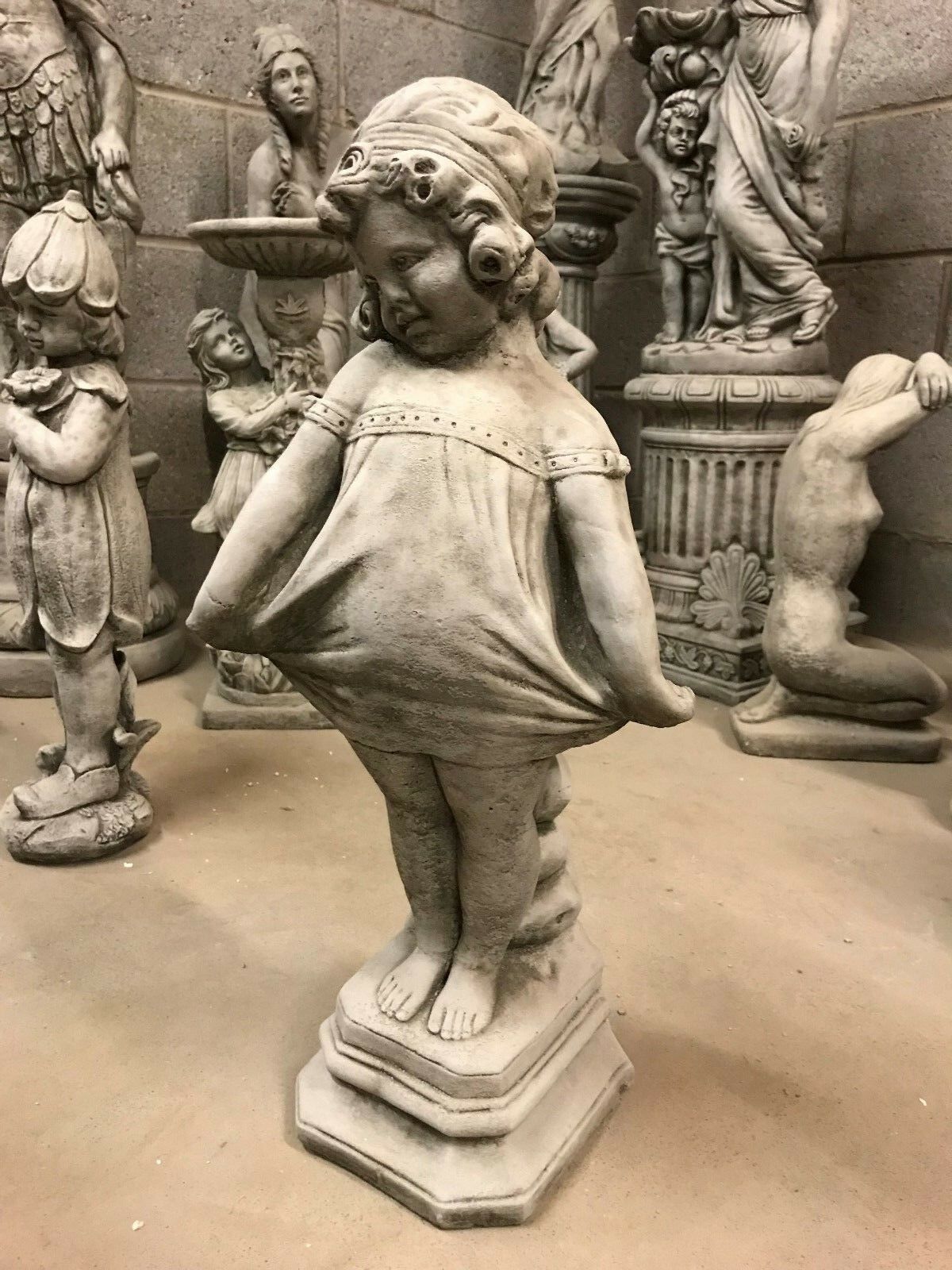 Shy Girl Stone Statue in antique finish, featuring a young girl holding her dress, ideal as a durable garden ornament for outdoor decor.