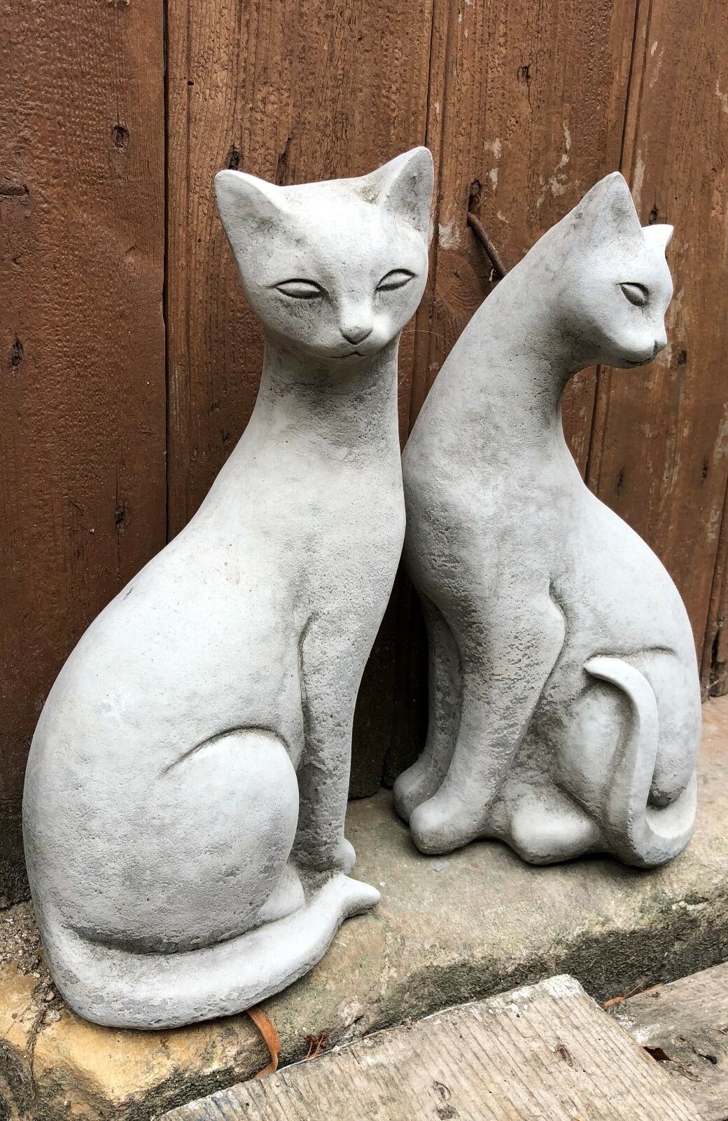 Garden Siamese Cat Statues - Stone Pair sitting side by side on a stone step, perfect for outdoor decor and weatherproof garden ornamentation.