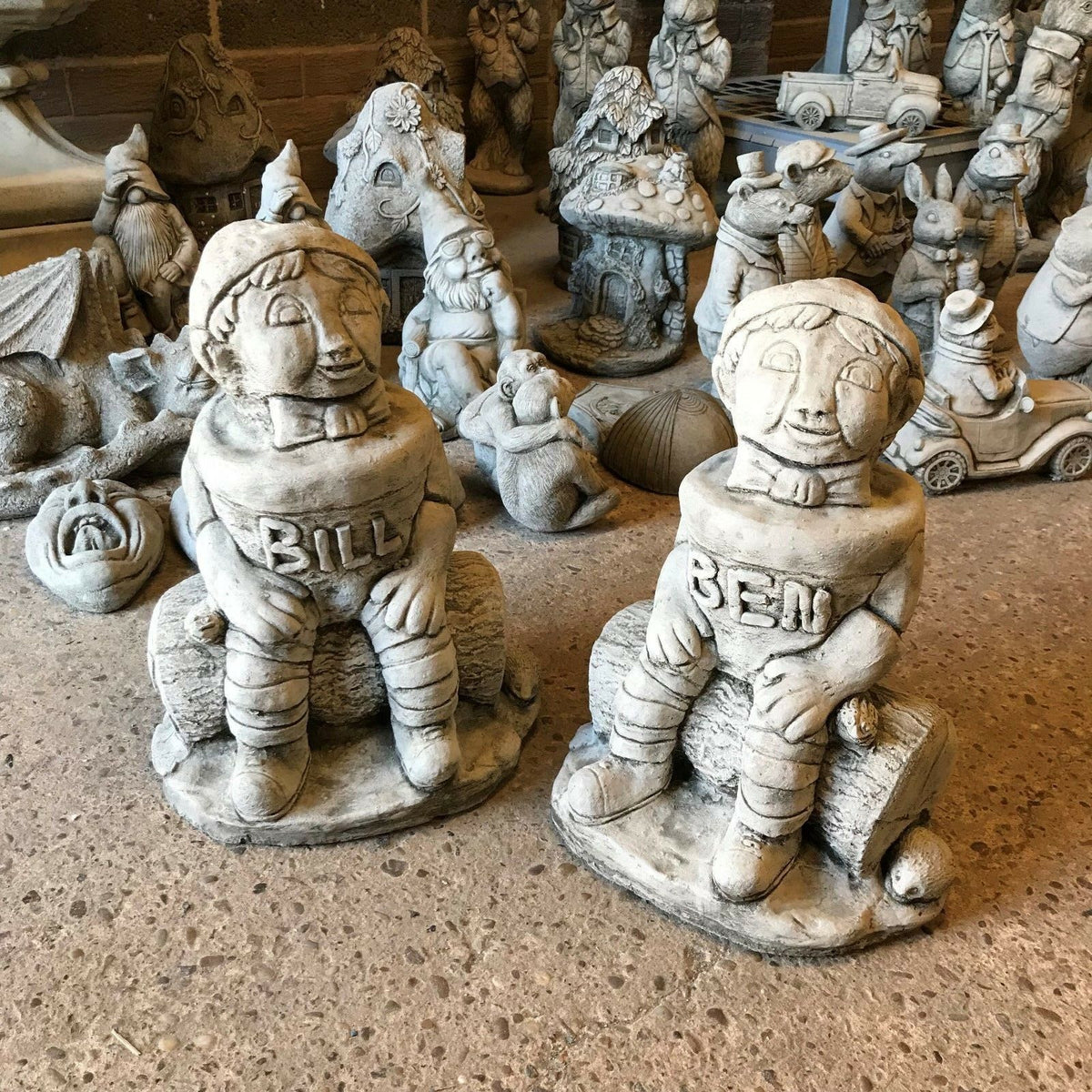 Stone Bill & Ben statues from the Garden Ornament Collection, seated on logs with detailed woodland creatures, ideal for outdoor decor.
