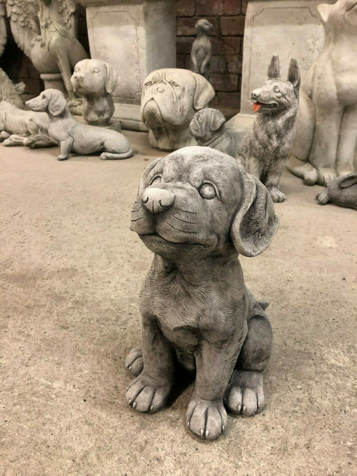 Stone puppy garden ornament in antique grey finish, sitting upright with detailed fur texture. Ideal for outdoor decoration and weather resistant.