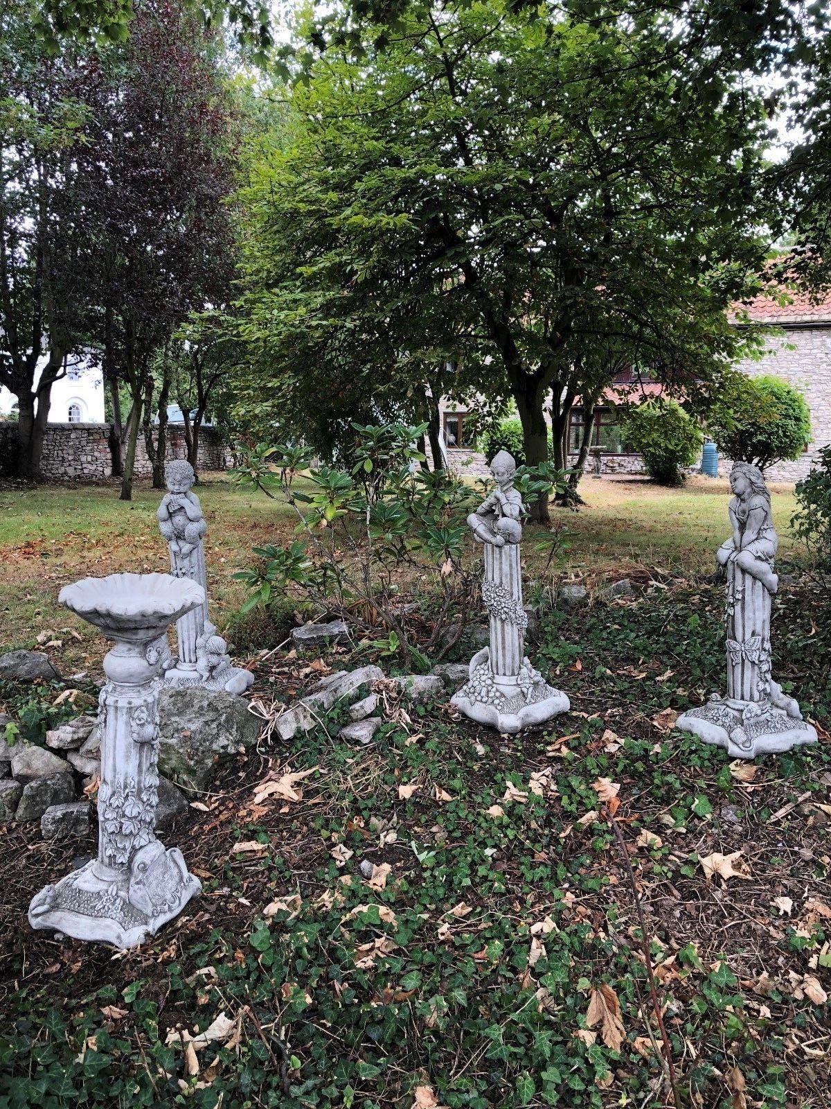 Full set of Four Seasons Garden Statues arranged outdoors, each representing a season with intricate stone carvings and symbolic elements.