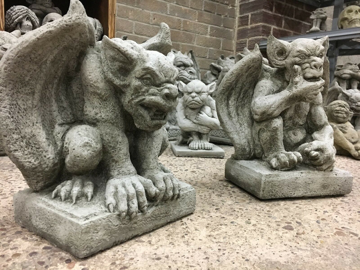 Detailed stone gargoyle pair with textured wings and muscular build, designed for weather-resistant garden ornamentation.
