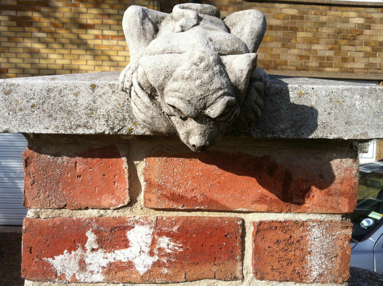 Close-up of a Gargoyle Garden Ornament in limestone stone design on a brick post, showcasing detailed craftsmanship and weather-resistant finish.