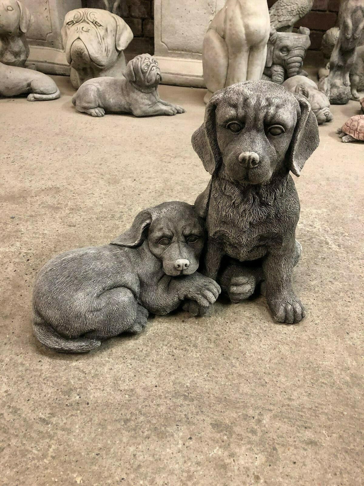 Stone Labrador dog statues pair featuring one sitting and one lying down, ideal for garden decor or lawn ornaments with lifelike detailing.