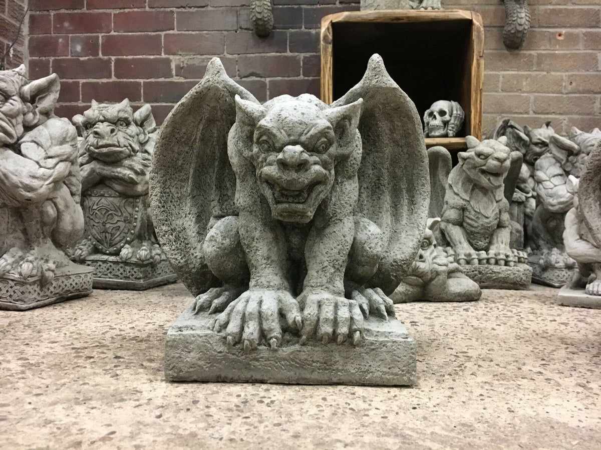 Close-up of snarling stone gargoyle statue with wings spread, a bold addition to gothic garden sculpture collections.