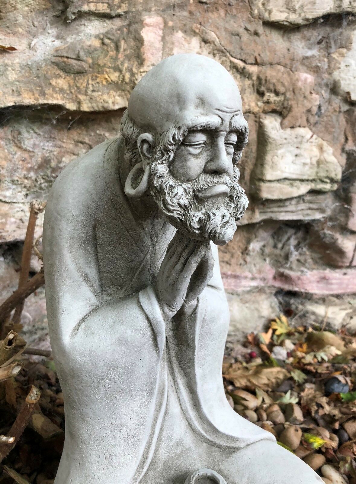 Detailed close-up of the Stunning Stone Praying Old Monk Sculpture Garden Ornament's contemplative face and textured beard.