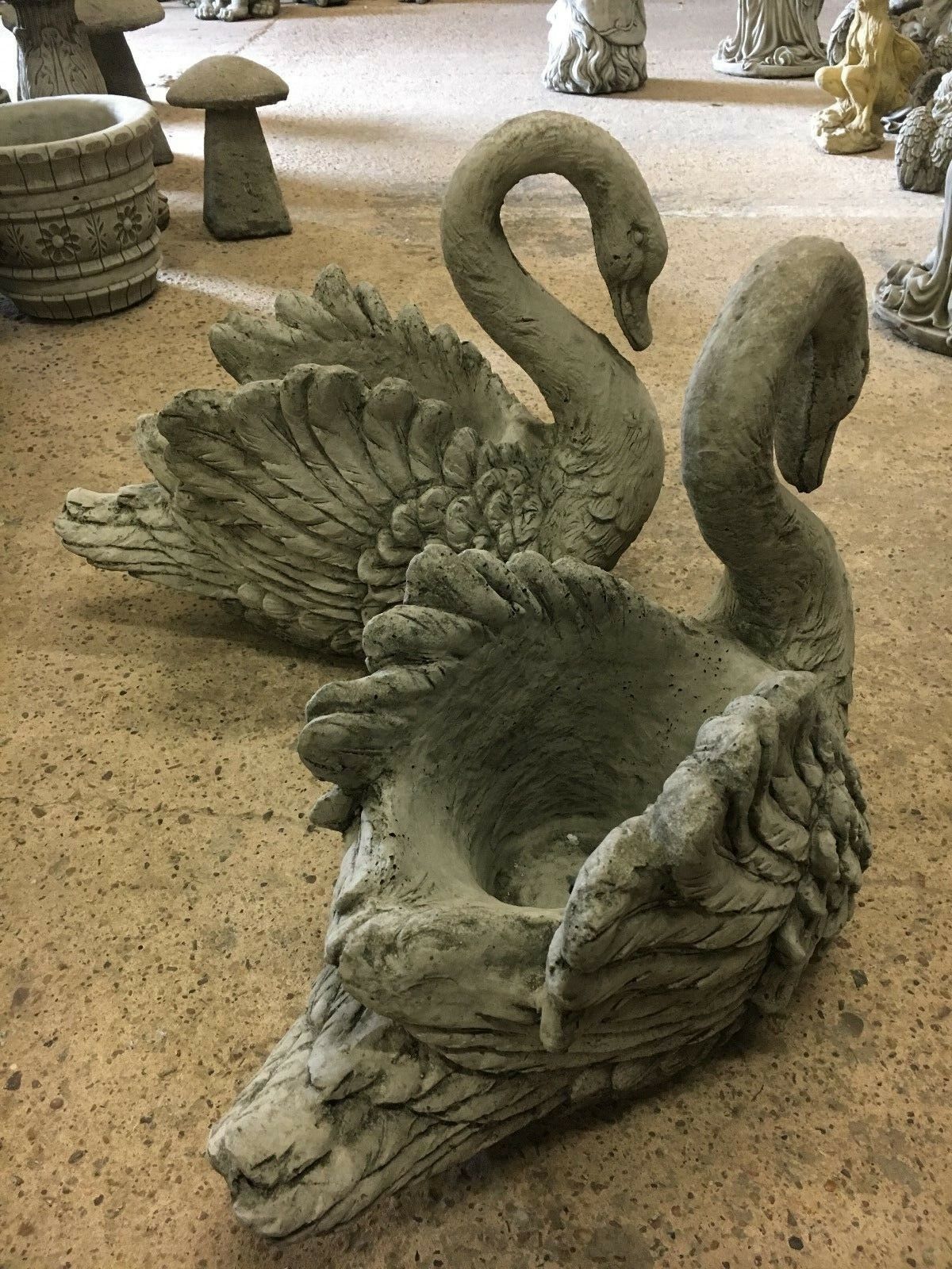 Two stone swan planters positioned together, showcasing ornamental garden decor with realistic swan features and durable stone finish.