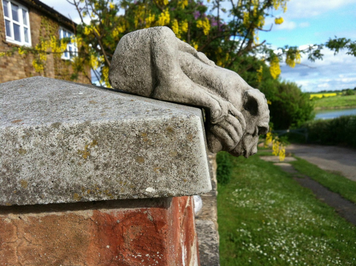 Side view of a Gargoyle Garden Ornament in antique stone finish mounted on a garden wall, perfect for gothic outdoor decoration and patio accents.