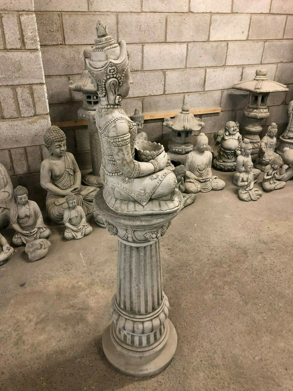 Side profile of Stone Seated Buddha Statue on fluted plinth, showcasing elegant craftsmanship for tranquil garden settings.