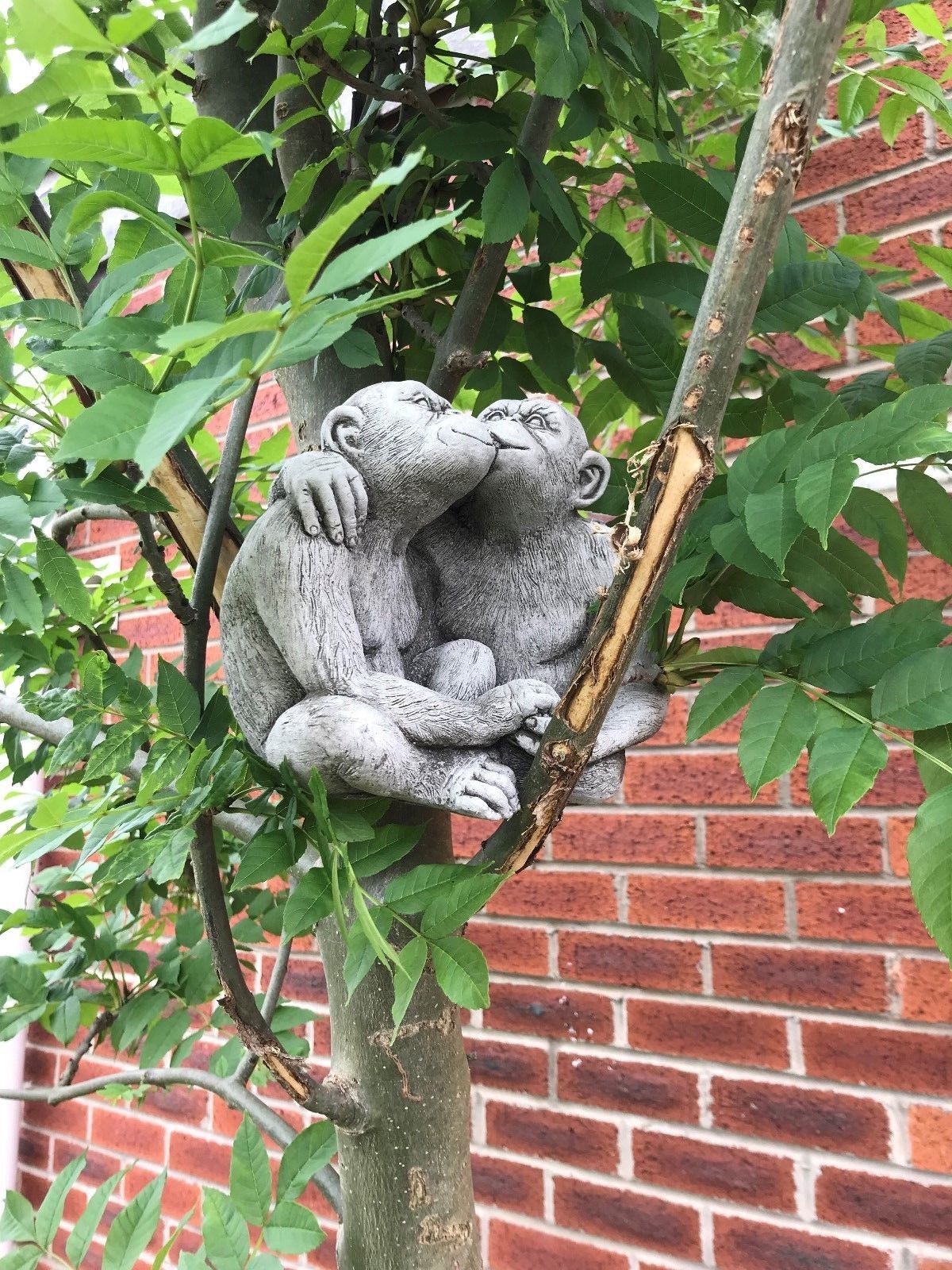 Romantic limestone monkey couple ornament kissing in a tree, a unique garden sculpture for home and outdoor decor.