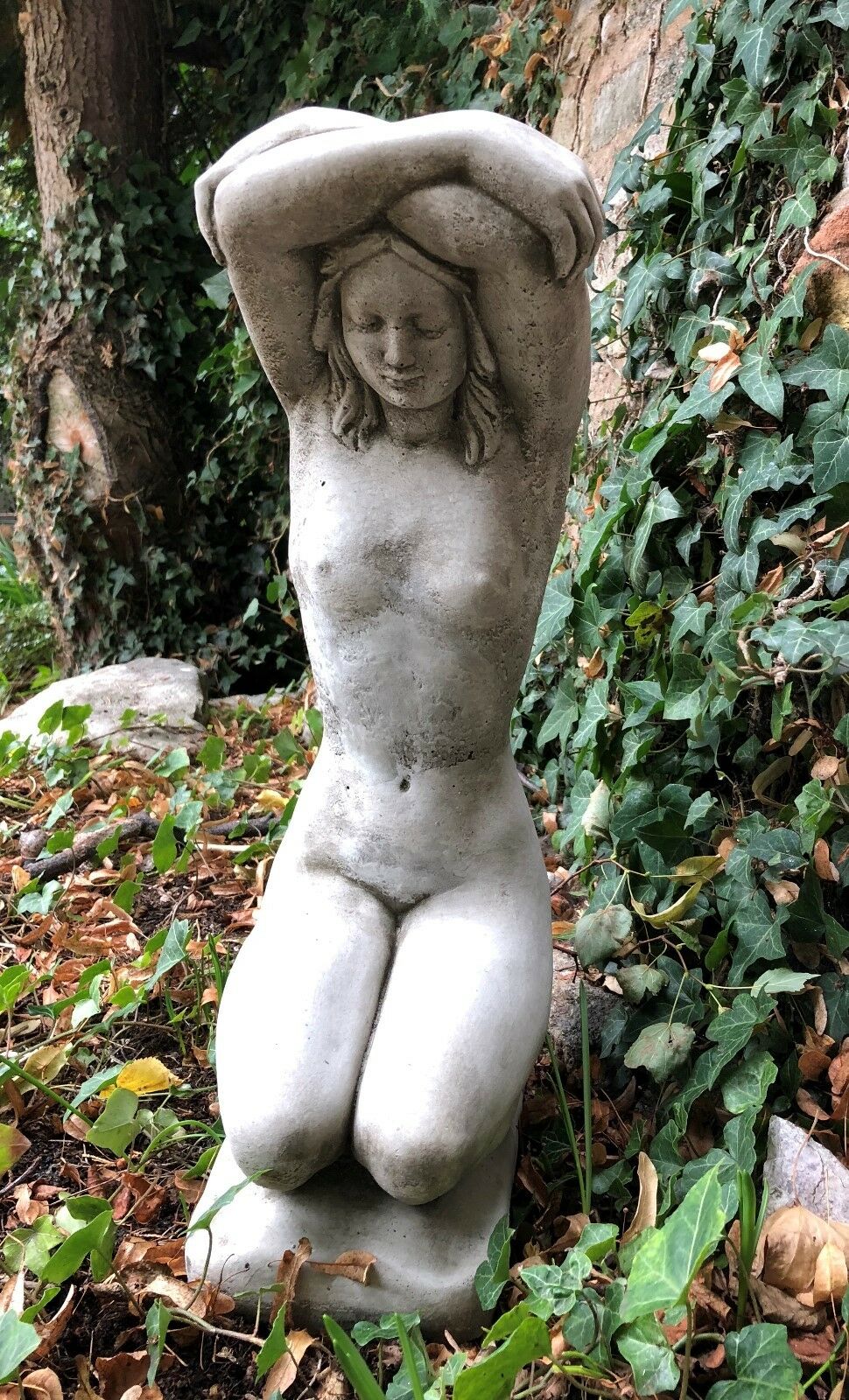 Stone Kneeling Nude Lady Garden Ornament with arms raised, detailed limestone sculpture for patios or lawn decoration. Crack-resistant finish.