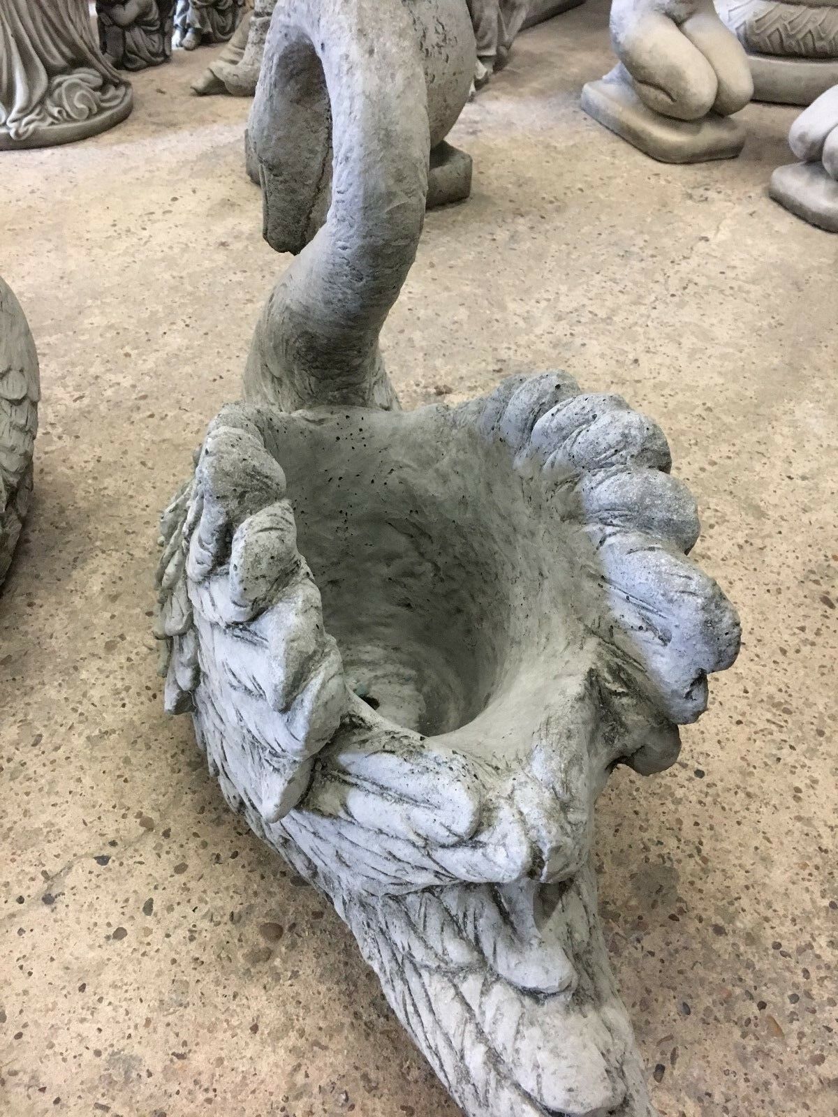 Rear angle of stone swan planter displaying textured wings and spacious planting area, suitable for outdoor decorative use.