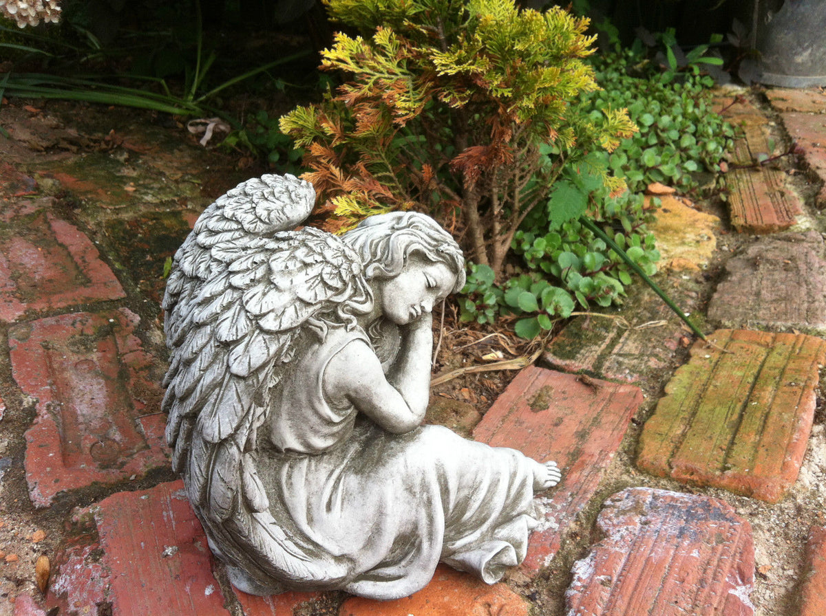 Detailed view of weather-resistant Winged Angel Ornament on rustic brick path, showcasing intricate feather and robe textures.