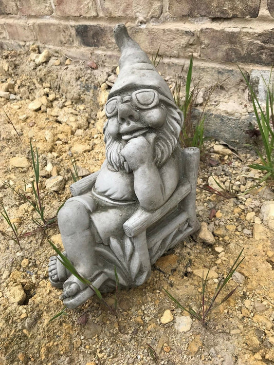 Stone Garden Gnome Ornament lounging in a chair with sunglasses, ideal for enhancing your outdoor space with a whimsical touch.