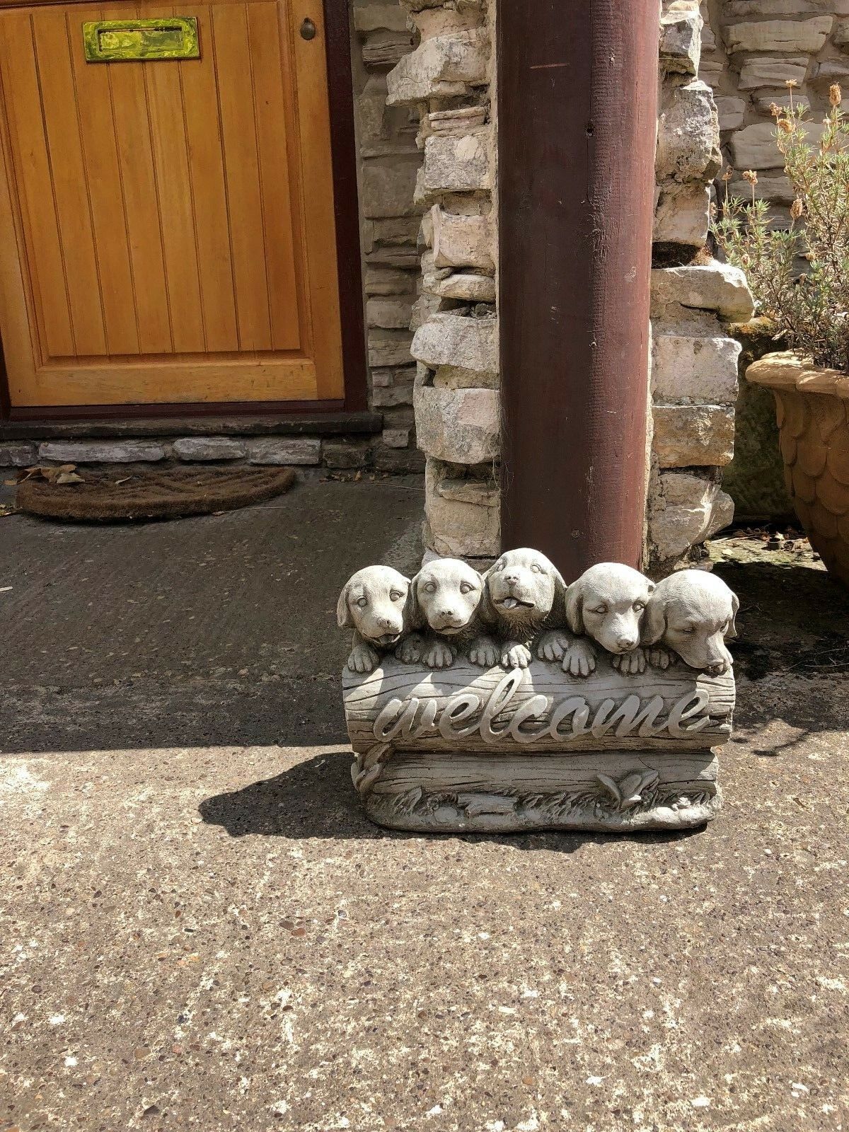 Outdoor stone puppy welcome sign with antique finish, adding a cute and inviting touch to home entrances or garden paths.