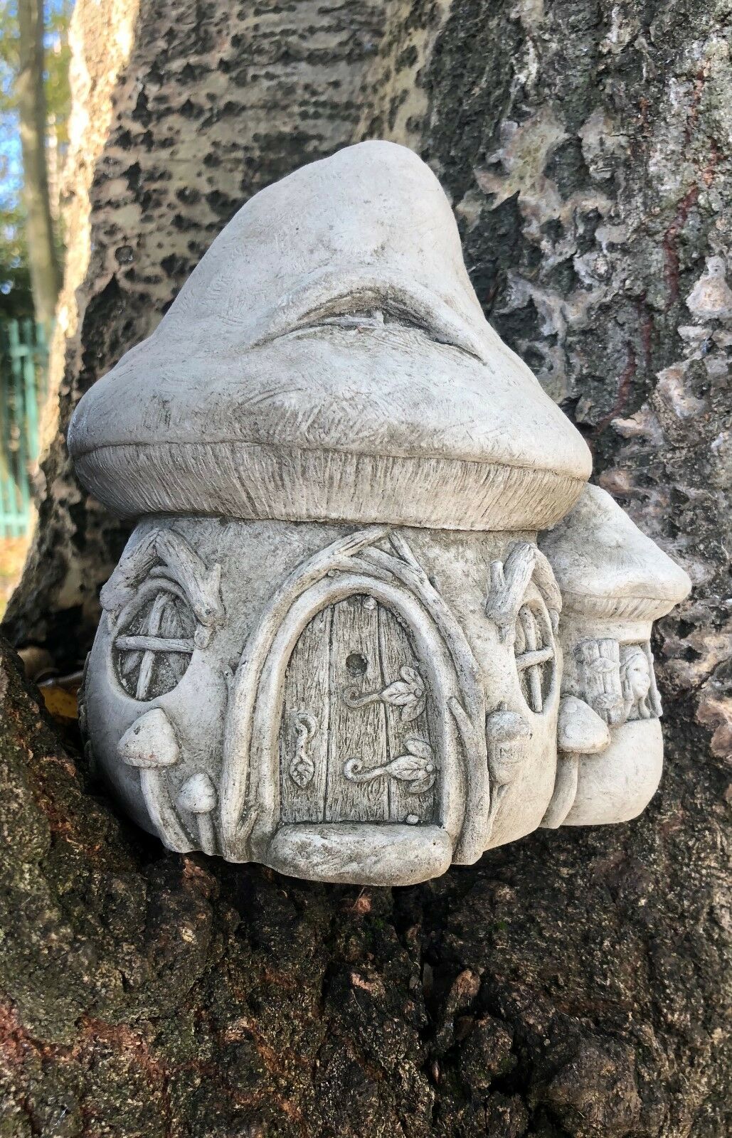 Stone Fairy Toadstool Garden Ornament placed in tree bark, showcasing its fairy-tale design for enchanting outdoor decoration.