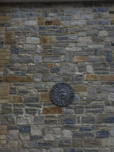 Sun moon wall plaque mounted on a stone exterior wall, adding a rustic decorative touch to outdoor spaces.