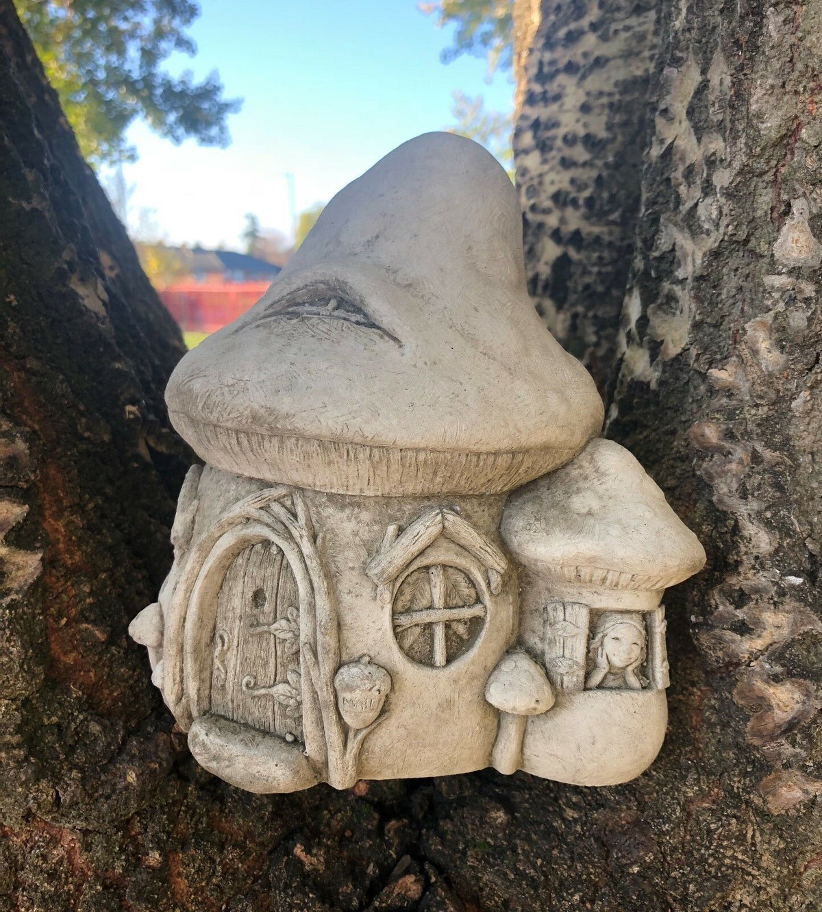 Whimsical Stone Fairy Toadstool House Ornament with round windows and mushroom details, ideal for patios or garden nooks.