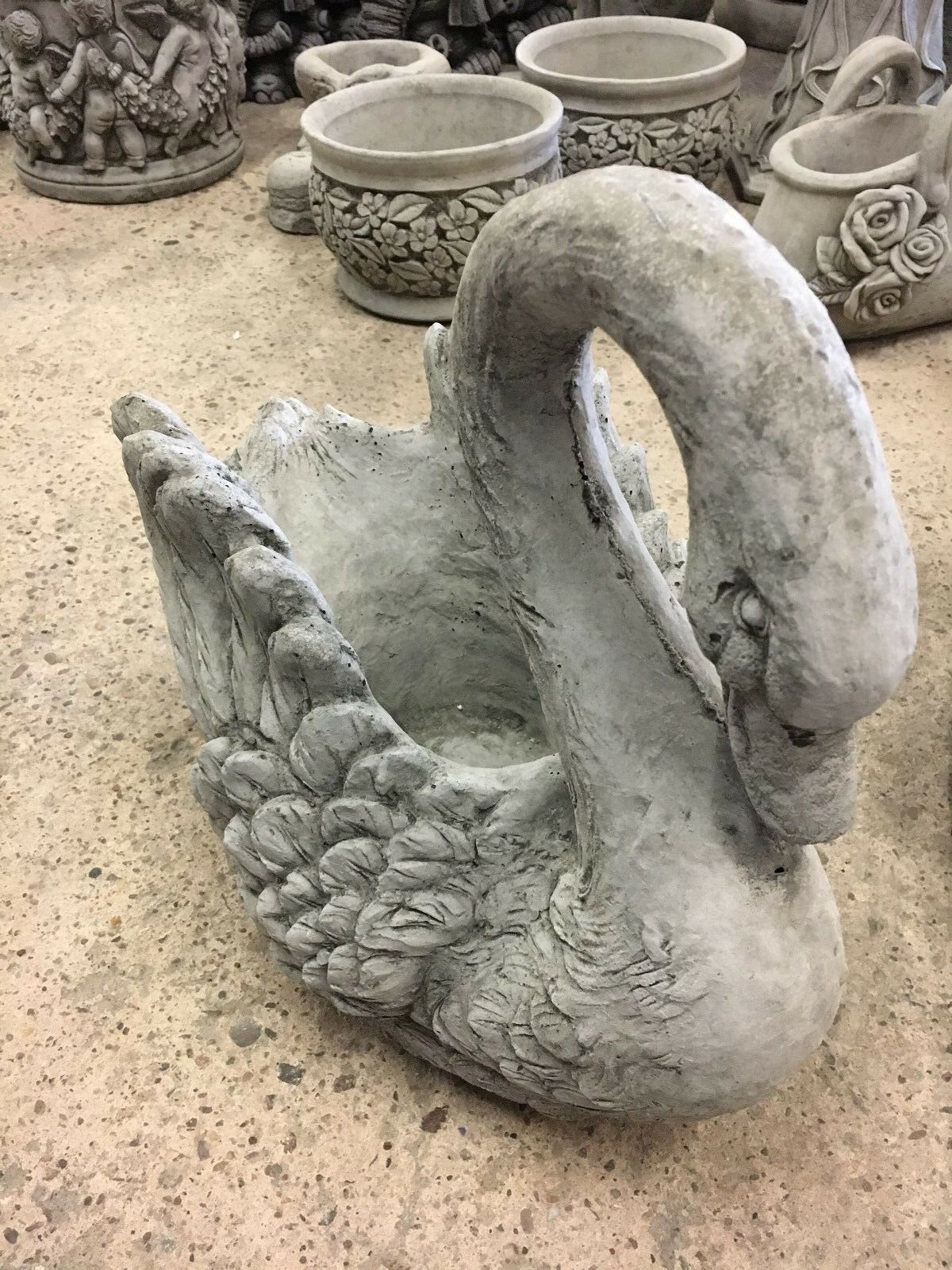 Front view of stone swan planter with detailed feather carvings and natural stone finish, designed for home and garden decoration.