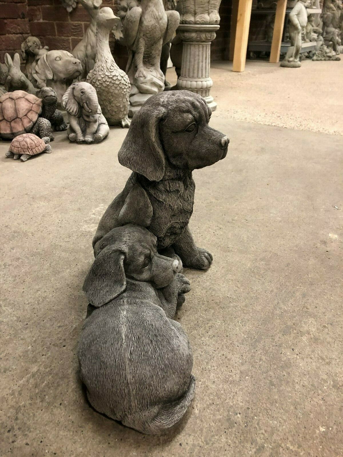 Angled view of stone Labrador dog statues pair, ideal for lawn ornaments or as charming garden sculpture decor.