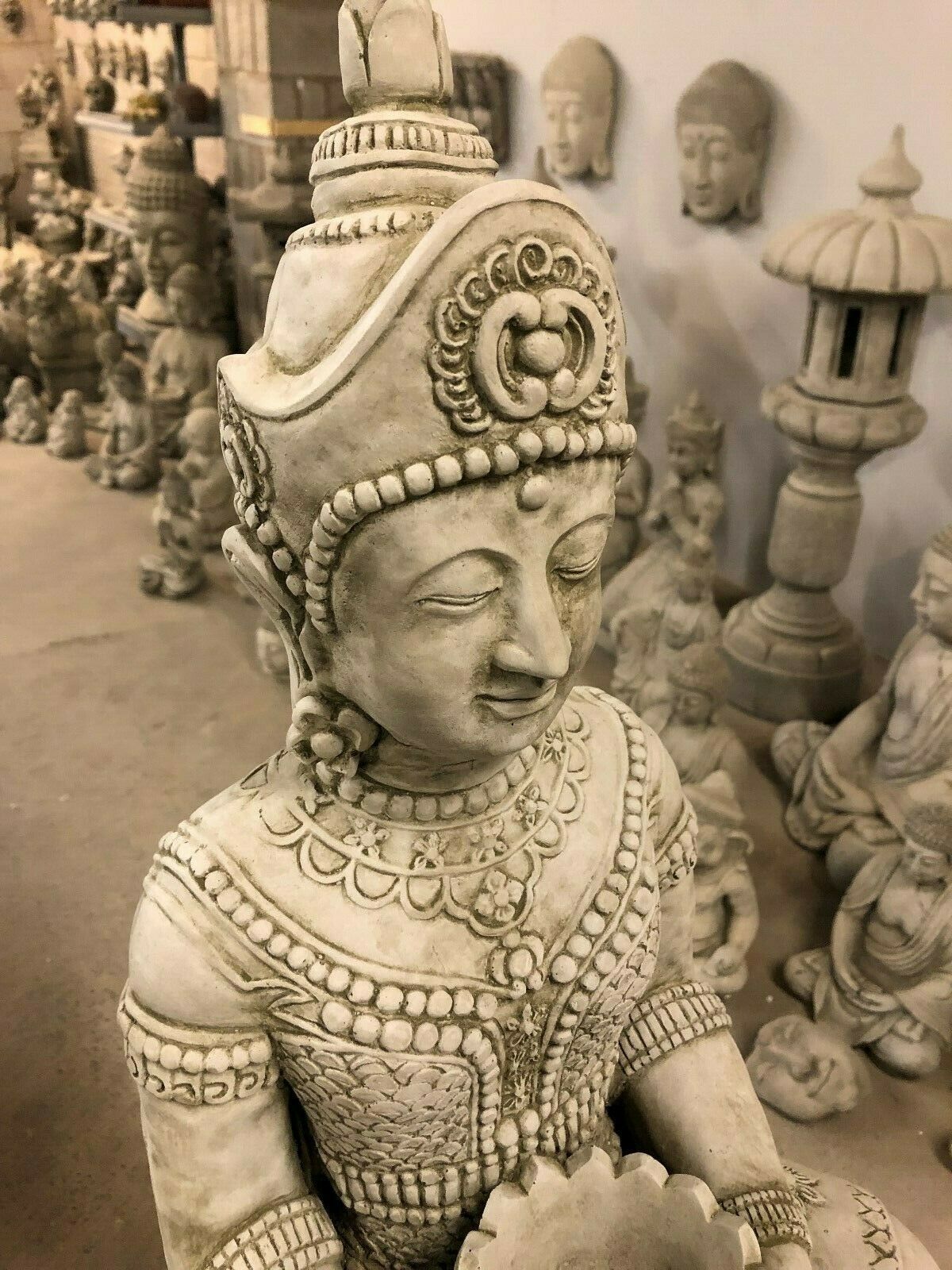 Close-up of Stone Seated Buddha Statue’s head and upper body, featuring ornate crown and peaceful facial expression.