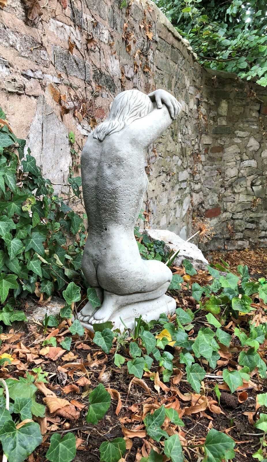 Rear view of Stone Kneeling Nude Lady Statue showing realistic back detail. Durable garden ornament for flowerbeds or patios.