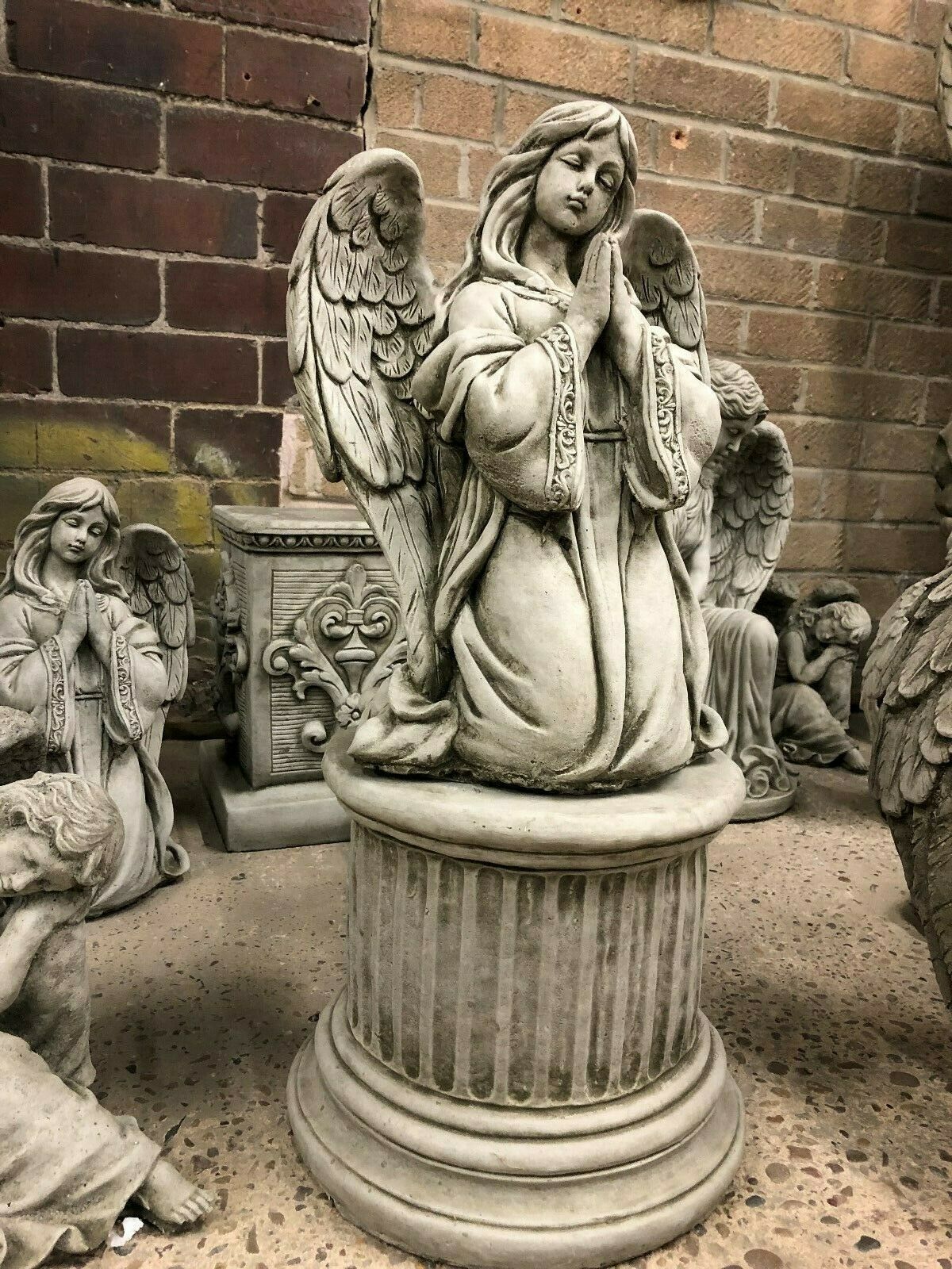 Elegant Garden Decor featuring a Durable Stone Praying Angel Statue on a classical column base. Perfect for patios, flower beds, or memorial spaces.